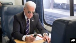 Joe Biden passe un appel téléphonique dans un train à la gare de Union Station à Washington, mardi 8 février 2011.