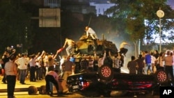 Quelques citoyens turcs barrent la route aux chars qui tentent de progresser, à Ankara, Turquie, 16 juillet 2016. (AP Photo)