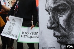 FILE - Anti-government protesters hold posters asking who killed opposition leader Boris Nemtsov as they march during an opposition rally in Moscow, Russia, Sept. 20, 2015. (Photo by M. Eckels)