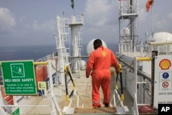 FILE - A Shell employee is seen aboard an oil vessel off the coast of Nigeria in this December 26, 2011, file photo.