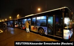 Orang-orang menaiki bus yang diatur untuk mengevakuasi penduduk setempat, di Kota Donetsk yang dikuasai pemberontak, Ukraina 18 Februari 2022. (Foto: REUTERS/Alexander Ermochenko)