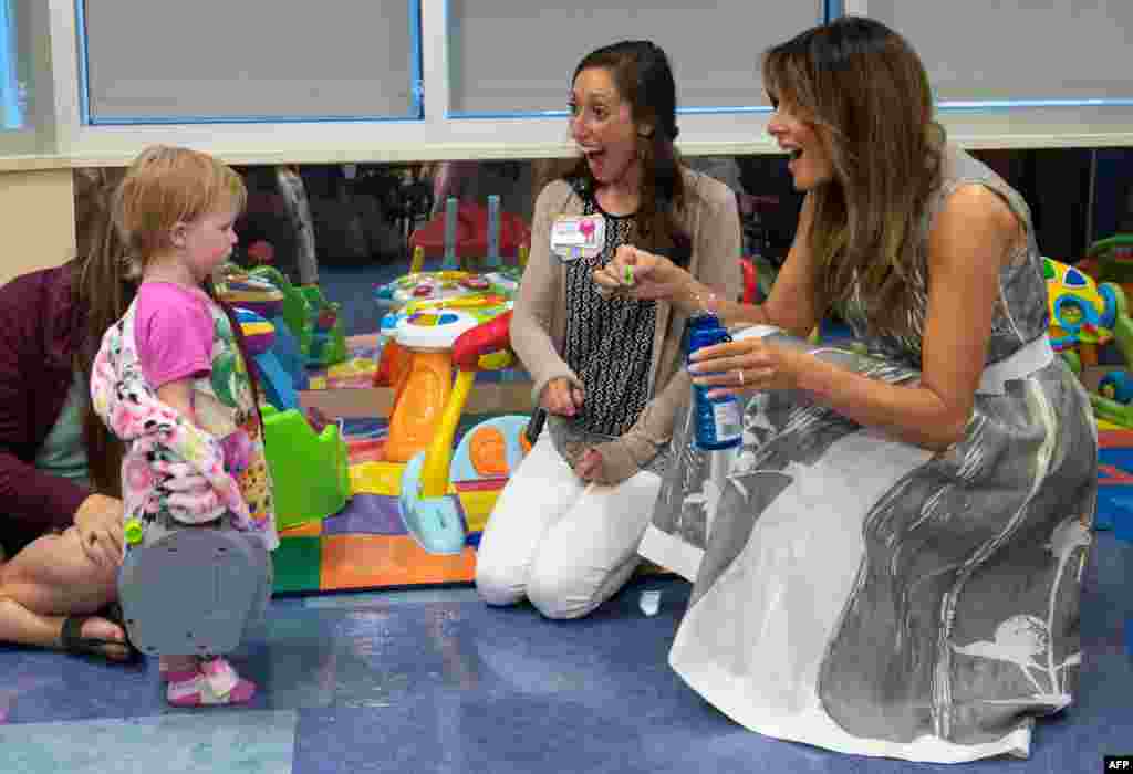 US First Lady Melania Trump blows bubbles with 18-month-old neonatal abstinence syndrome patient Elliegh Rasmussen during a visit to Monroe Carell Jr. Children's Hospital at Vanderbilt in Nashville, Tennessee.