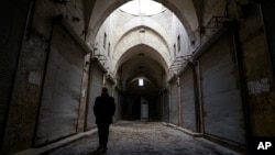 A Syrian man walks through Aleppo's centuries-old market. which still hasn't come back to life more than a year after government forces retook rebel-held neighborhoods around the Old City, Jan. 21, 2018. 