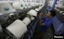 FILE - A man works at a yarn weaving plant in Ha Nam province, outside Hanoi, Vietnam, Oct. 7, 2015.