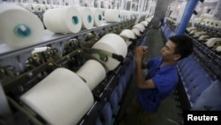 FILE - A man works at a yarn weaving plant in Ha Nam province, outside Hanoi, Vietnam, Oct. 7, 2015.