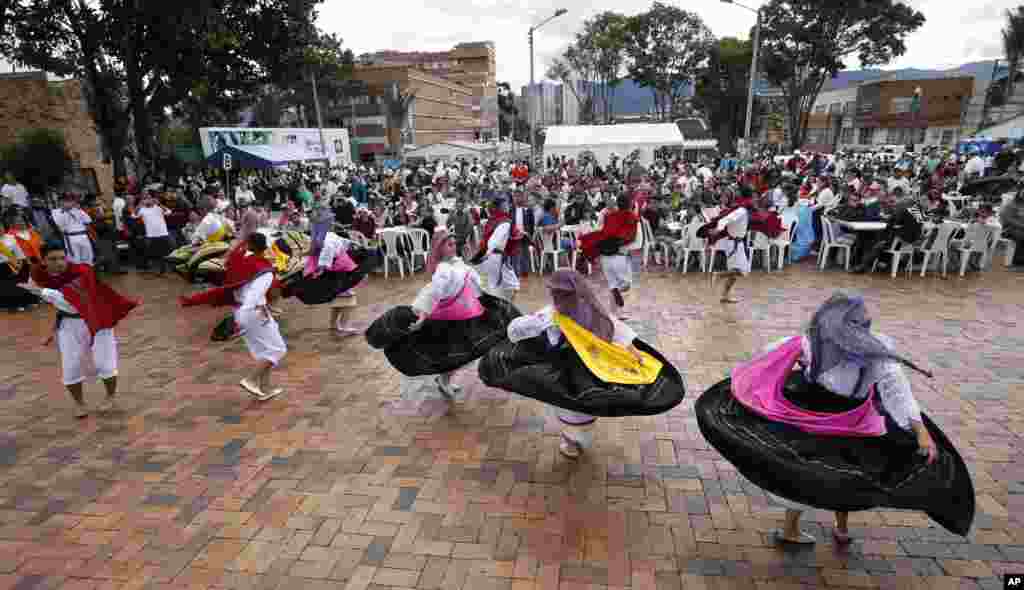 Colombian dancers perform during an outdoor breakfast for Venezuelan migrants organized by &quot;El Minuto de Dios&quot; Corporation, in Bogota, Colombia, November 18, 2018.