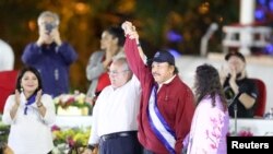 El presidente de la Asamblea Nacional de Nicaragua, Gustavo Porras, y el presidente de Nicaragua, Daniel Ortega, se dan la mano junto a la vicepresidenta Rosario Murillo, durante la inauguración del cuarto mandato consecutivo de Ortega, en Managua, Nicaragua, el 10 de enero de 20