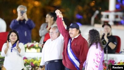 El presidente de la Asamblea Nacional de Nicaragua, Gustavo Porras, y el presidente de Nicaragua, Daniel Ortega, se dan la mano junto a la vicepresidenta Rosario Murillo, durante la inauguración del cuarto mandato consecutivo de Ortega, en Managua, Nicaragua, el 10 de enero de 20