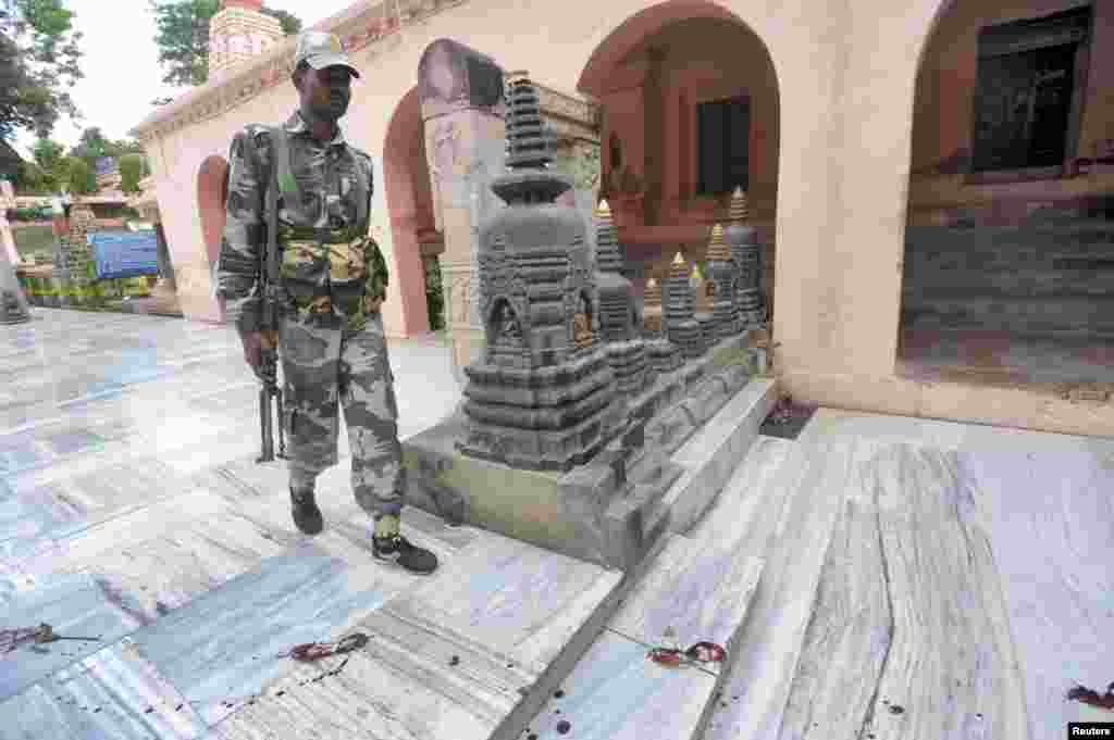 An Indian security personnel walks next to bloody footprints inside the Mahabodhi temple complex, after a series of explosions at Bodh Gaya in the eastern Indian state of Bihar, July 7, 2013.