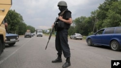 A Ukrainian soldier controls a road on the outskirts of Izyum, Eastern Ukraine, May 30, 2014. 