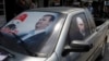 Hình ảnh Tổng thống Syria Bashar al-Assad và Tổng thống Nga Vladimir Putin trên kính một chiếc xe gần thị trấn Latakia, Syria.