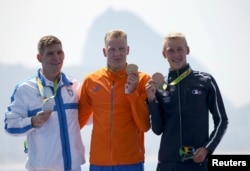 Gold medalist Ferry Weertman (NED) of the Netherlands, silver medalist Spiros Gianniotis (GRE) of Greece (L) and bronze medalist Marc-Antoine Olivier (FRA) of France (R) pose with their medals for Men's 10km Marathon Swimming, Rio de Janeiro, Aug. 16, 2016.