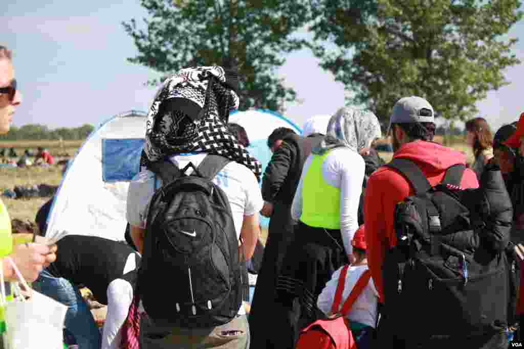 Hundreds of people waited outside the temporary camp all day on Tuesday, saying bad weather along with a lack of food and water are making more and more people sick, Opatovac, Croatia, Sept. 22, 2015. (Heather Murdock/VOA)