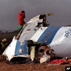 Police and investigators look at what remains of the flight deck of Pan Am 103 on a field in Lockerbie, Scotland, December 22, 1988 file photo