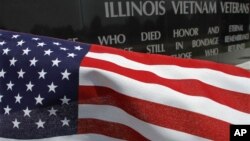 A United States flag blows in the wind near the Illinois Vietnam Memorial, July 3, 2012, in Springfield, Ill. 