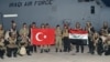 FILE - Turkish and Iraqi soldiers hold their national flags after the arrival of Iraqis in Silopi, near the Habur border gate with Iraq, southeastern Turkey, Sept. 25, 2017. 