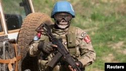 FILE - A United Nations peacekeeping soldier provides security during a food aid delivery by the United Nations Office for the Coordination of Humanitarian Affairs and world food program in the village of Makunzi Wali, Central African Republic, April 27. 