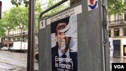 This campaign poster, like many others in Paris, was defaced, May 6, 2017. France's election has been marked by dissatisfaction with both candidates and deep anti-establishment sentiments. (Photo: L. Ramirez/VOA)