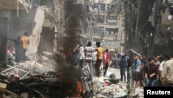 People inspect the damage at a site hit by airstrikes, in the rebel-held area of Aleppo's Bustan al-Qasr, Syria April 28, 2016.