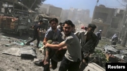 FILE - Men transport a casualty after what activists said were airstrikes by forces loyal to Syria's President Bashar al-Assad on a busy marketplace in Douma, near Damascus, Syria, Aug. 12, 2015. 