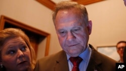 FILE - Republican U.S. Senate candidate Roy Moore, center, looks at election returns with staff during an election-night watch party, Dec. 12, 2017, in Montgomery, Alabama.