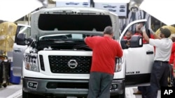 FILE - Technicians make final inspections to vehicles on an assembly line at the Nissan Canton Assembly Plant, in Canton, Mississippi, March 19, 2018.