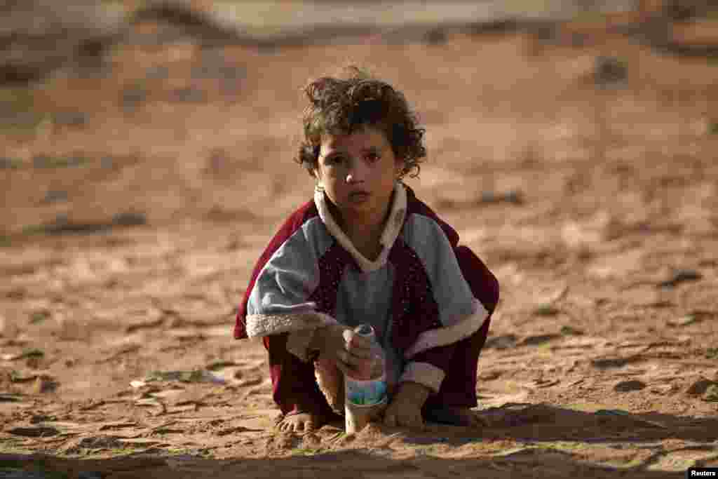 یک دختر مهاجر عراقی که با خانواده اش از خشونت موصل فرار کرده بود، در حلب سوریه شن بازی می&zwnj;&zwnj;کند.