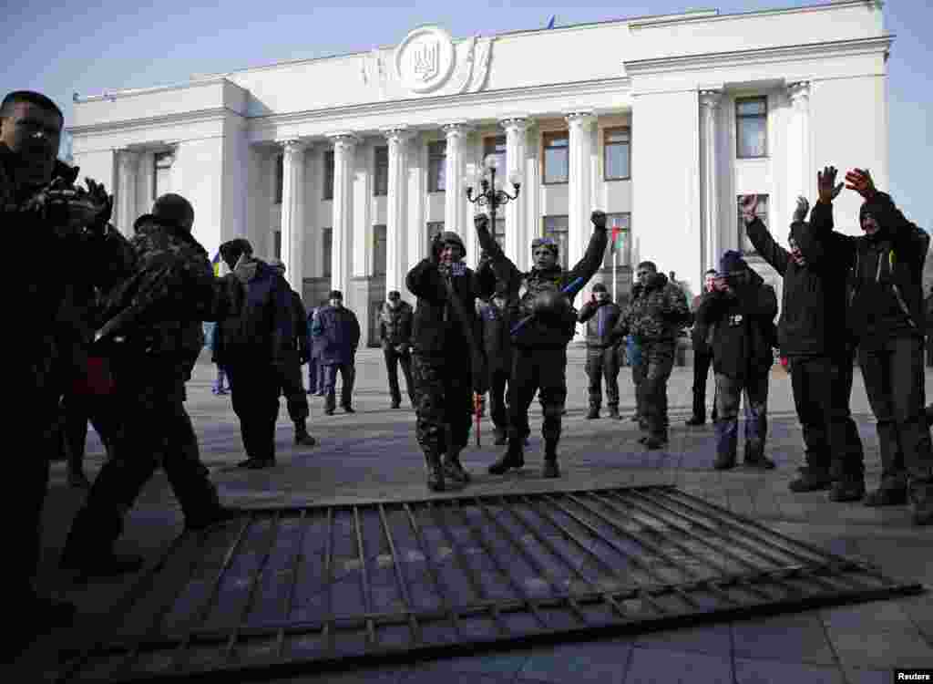 Members of self-defense units react after demolishing a fence enclosing the parliament building in Kyiv, Feb. 26, 2014.