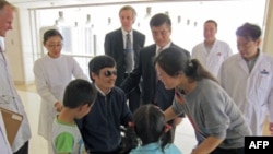 Blind activist Chen Guangcheng speaks with his wife Yuan Weijing and children as U.S. ambassador to China Gary Locke.