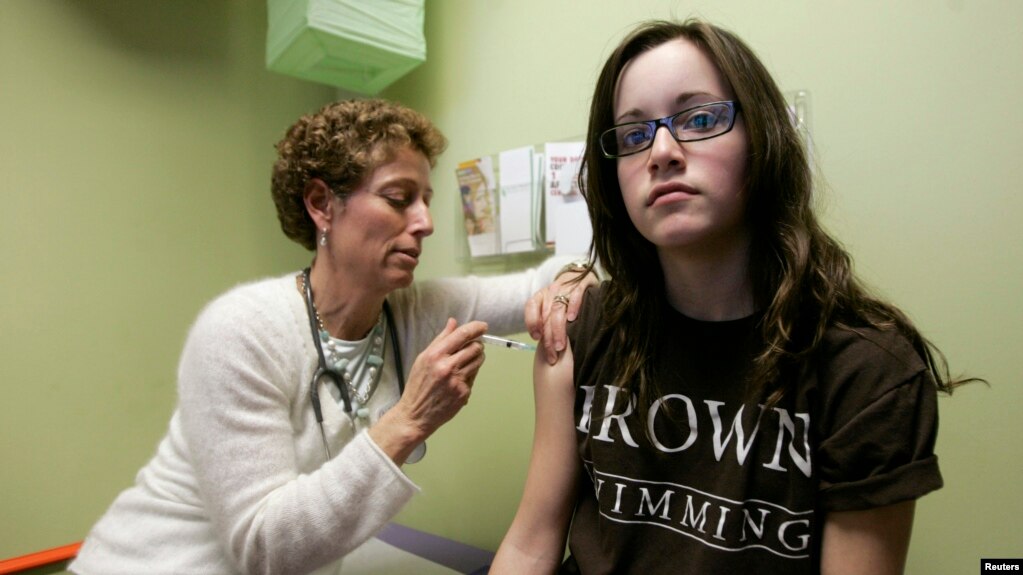 Nancy Brajtbord, RN, (kiri) sedang menyuntikkan vaksin Human Papillomavirus (HPV) kepada seorang remaja, di Dallas, Texas, 6 Maret 2018.