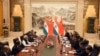 In this photo released by the Indian Ministry of External Affairs, Indian Prime Minister Narendra Modi, center left, and Chinese President Xi Jinping, center right, sit with delegation members for a meeting in Wuhan, China, April 27, 2018. 