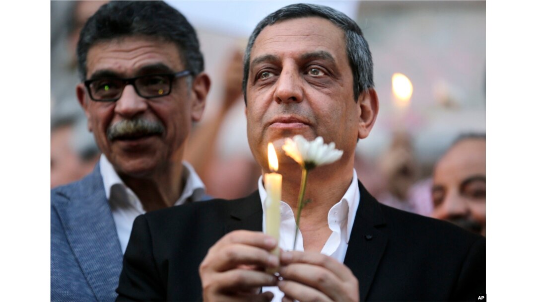 Yehia Qalash, the head of the journalists' union, holds a candle during a candlelight vigil for the victims of EgyptAir flight 804 in front of the Journalists' Syndicate in Cairo, May 24, 2016.