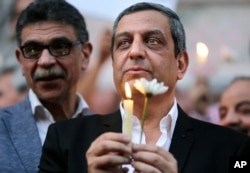 Yehia Qalash, the head of the journalists' union, holds a candle during a candlelight vigil for the victims of EgyptAir flight 804 in front of the Journalists' Syndicate in Cairo, May 24, 2016.
