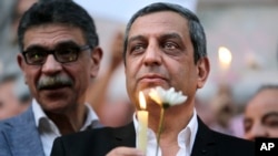 FILE - Yehia Qalash, the head of the journalists' union, holds a candle during a candlelight vigil for the victims of EgyptAir flight 804 in front of the Journalists' Syndicate in Cairo, May 24, 2016.