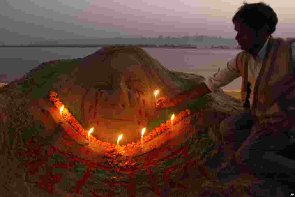 Художник Радж Капур тримає свічку над скульптурою на згадку про жертву групового зґвалтування, яка померла у суботу.