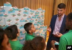 FILE - Colgate global ambassador Michael Phelps speaks to students in Celebration of Campus Sustainability Month at Alain L. Locke Magnet School, Oct. 19, 2017, in New York.