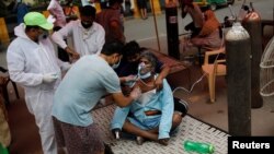 Seorang pria yang kesulitan bernapas sedang dibantu dengan oksigen di kuil Sikh, Gurudwara, di tengah lonjakan kasus virus corona (COVID-19) di Ghaziabad, Senin, 3 Mei 2021. (Foto: Adnan Abidi/Reuters)