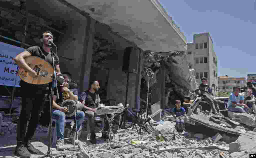 Members of the Palestinian band Dawaween perform on the remains of a building that was recently destroyed by Israeli airstrikes, in Gaza City, during a musical event calling for a boycott of the Eurovision Song Contest, hosted by Israel.