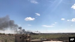 Columns of black smoke rise from the last small piece of territory held by Islamic State militants as U.S. backed fighters pound the area with artillery fire and occasional airstrikes, as seen from outside Baghuz, Syria, March 3, 2019. 