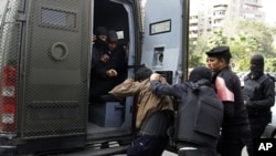 Egyptian security forces detain a man during clashes with supporters of ousted President Mohamed Morsi in the Nasr City neighborhood of Cairo, Egypt, Friday, Jan. 17, 2014.
