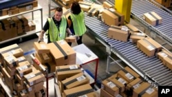 In this file photo, Amazon employees organize outbound packages at an Amazon.com Fulfillment Center on "Cyber Monday." Amazon has dropped some shoppers who returned too many purchases. (AP Photo/Ross D. Franklin)