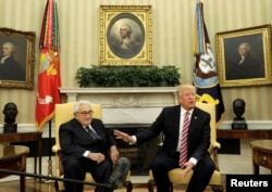 With former Secretary of State Henry Kissinger (L) at his side, U.S. President Donald Trump speaks to reporters