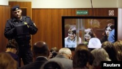 A bailiff stands in a room as people watch a live broadcast of a court hearing on members of the female punk band Pussy Riot in Moscow, October 10, 2012. 