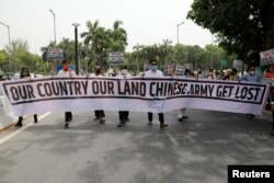 印度示威者在新德里手举写着“我们的国家我们的土地，中国军队滚出去”字样的横幅举行抗议活动。（2020年6月19日）