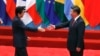 FILE - Japanese Prime Minister Shinzo Abe, left, and Chinese President Xi Jinping approach each other for a handshake before a group photo session for the G-20 Summit in Hangzhou, in eastern China's Zhejiang province, Sept. 4, 2016. The two will meet Thursday, when Abe starts a three-day visit to China.