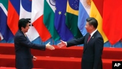 日本首相安倍晋三和中国国家主席习近平在中国杭州举行的20国集团峰会上握手。（2016年9月4日）