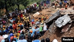 Rescuers search for people trapped in a landslide caused by Typhoon Mangkhut at a small-scale mining camp in Itogon, Benguet, in the Philippines, Sept. 17, 2018. 