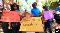 FILE - An albino child, center, joins marchers demanding equal rights for members of Zimbabwe's albino community, in Harare, June, 18, 2016.