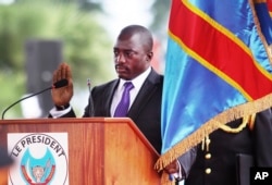 FILE - Incumbent Congo President Joseph Kabila holds the Congolese flag as he takes the oath of office as he is sworn in for another term, in Kinshasa, Democratic Republic of Congo.