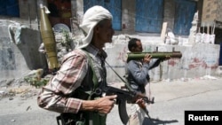 Anggota Komite Pertahanan Populer mengambil posisi dalam bentrokan dengan pemberontak Houthi di kota Taiz, Yaman barat daya (21/4). 